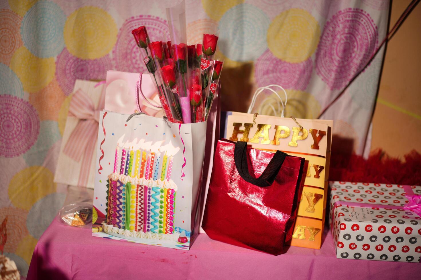 a table with a birthday cake, a bag of candy, and a bag of birthday candles photo