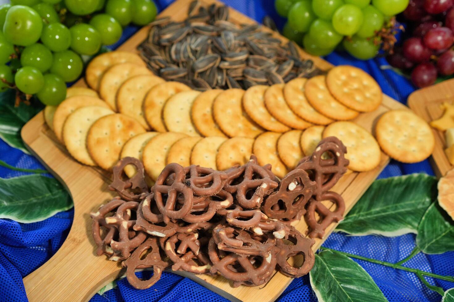 a variety of snacks and crackers on a wooden board photo