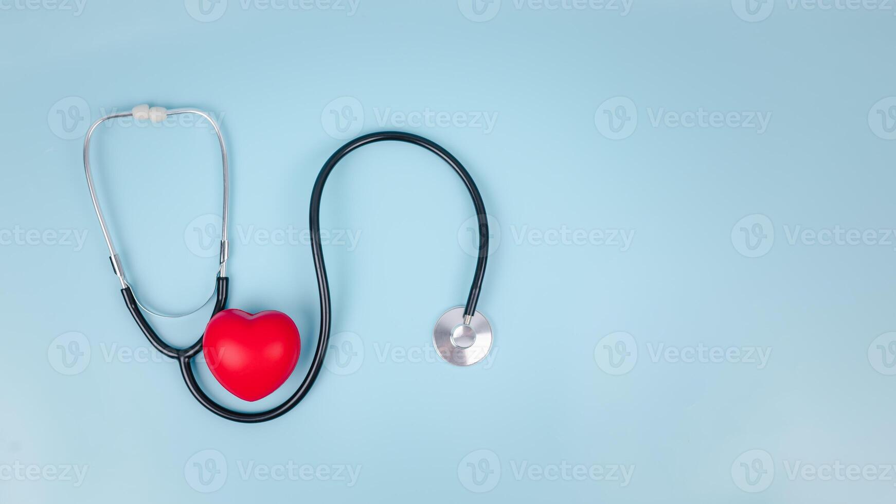 Stethoscope and red hearts on light blue background, Health care concept, Hospital life insurance concept, World heart health day, Doctor day, World hypertension day. photo