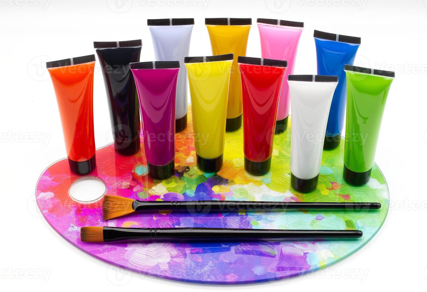 Colorful tubes of paint on a palette with brushes, isolated on white background. photo