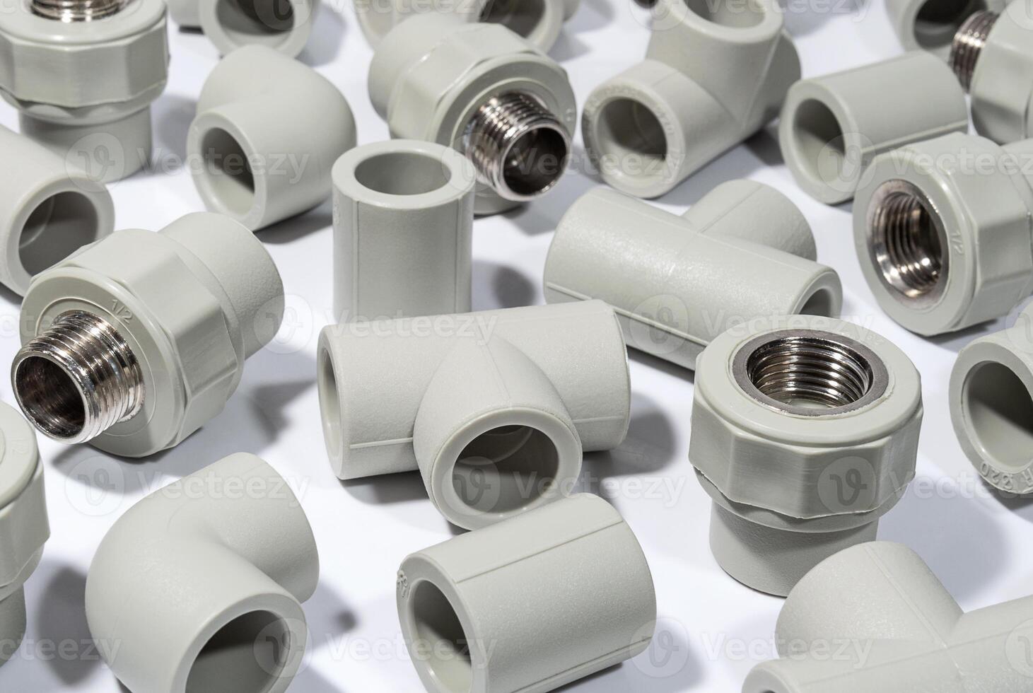Plastic fittings for polyprpylene water pipelines on white surface. Building and plumbing accessories photo