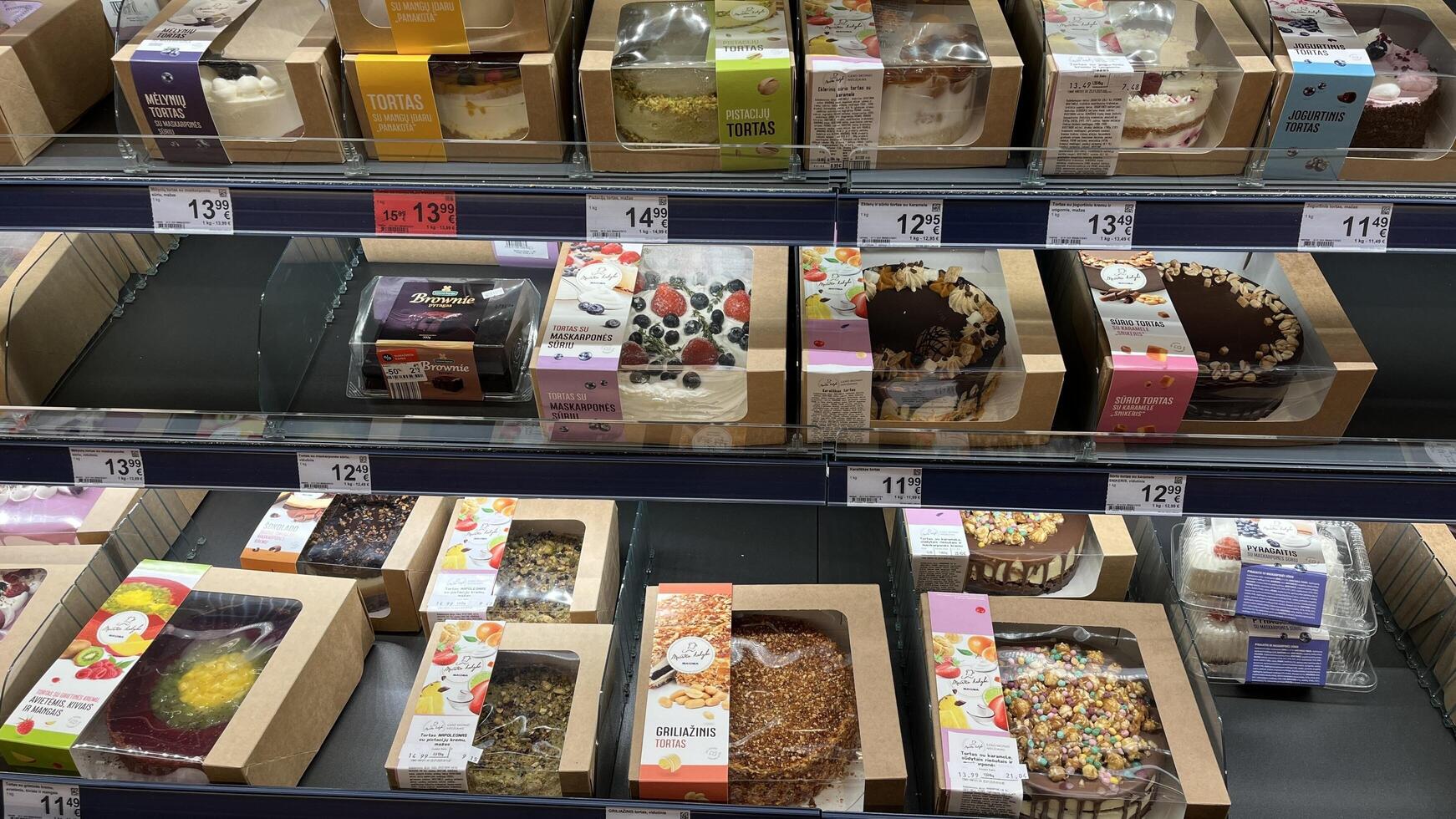Kaunas, Lithuania. January 24, 2025. A well-stocked refrigerated display case showcases a variety of beautifully packaged cakes and desserts in a grocery store setting. photo