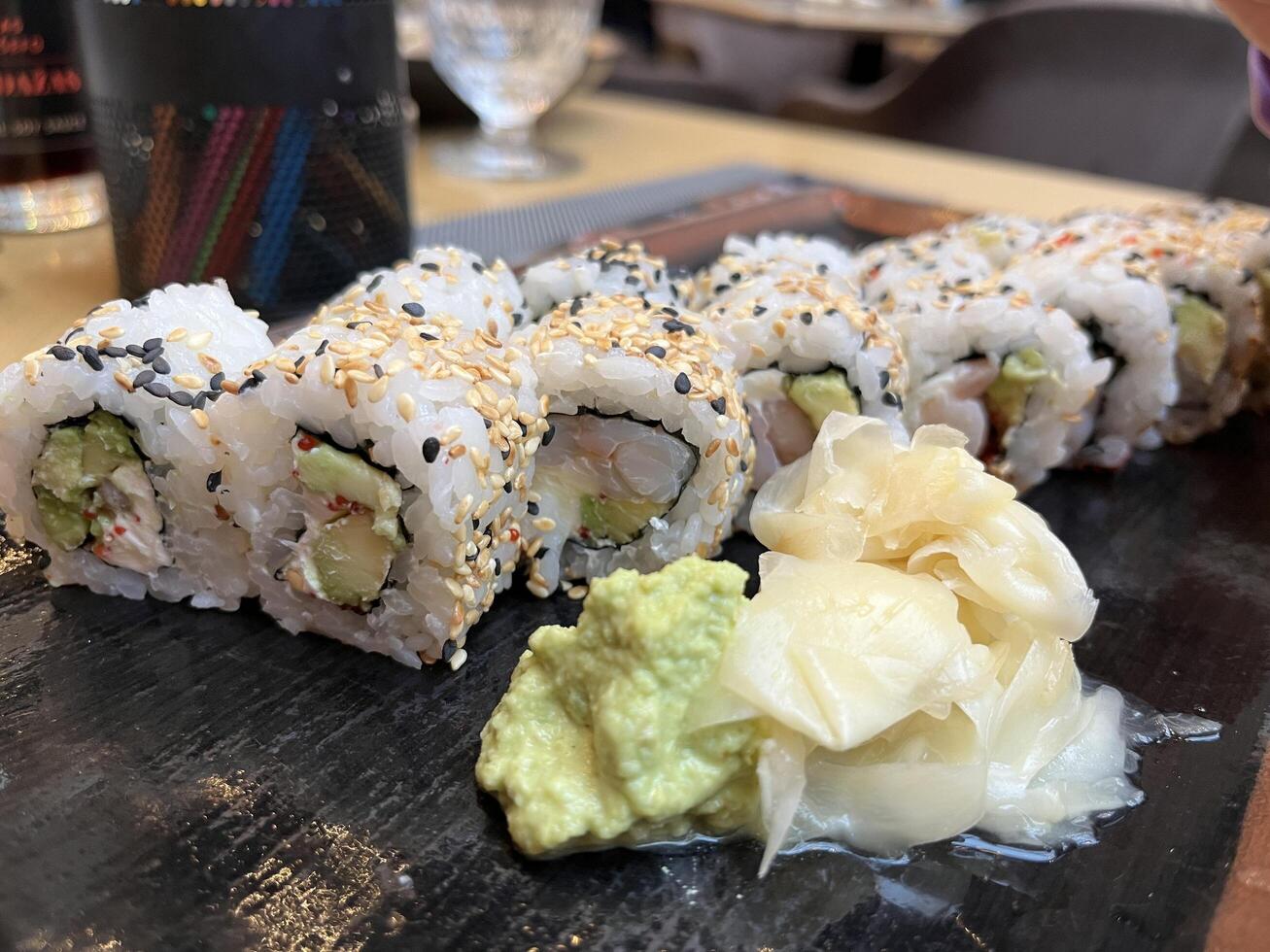 Sushi roll on black plate in Japanese restaurant photo
