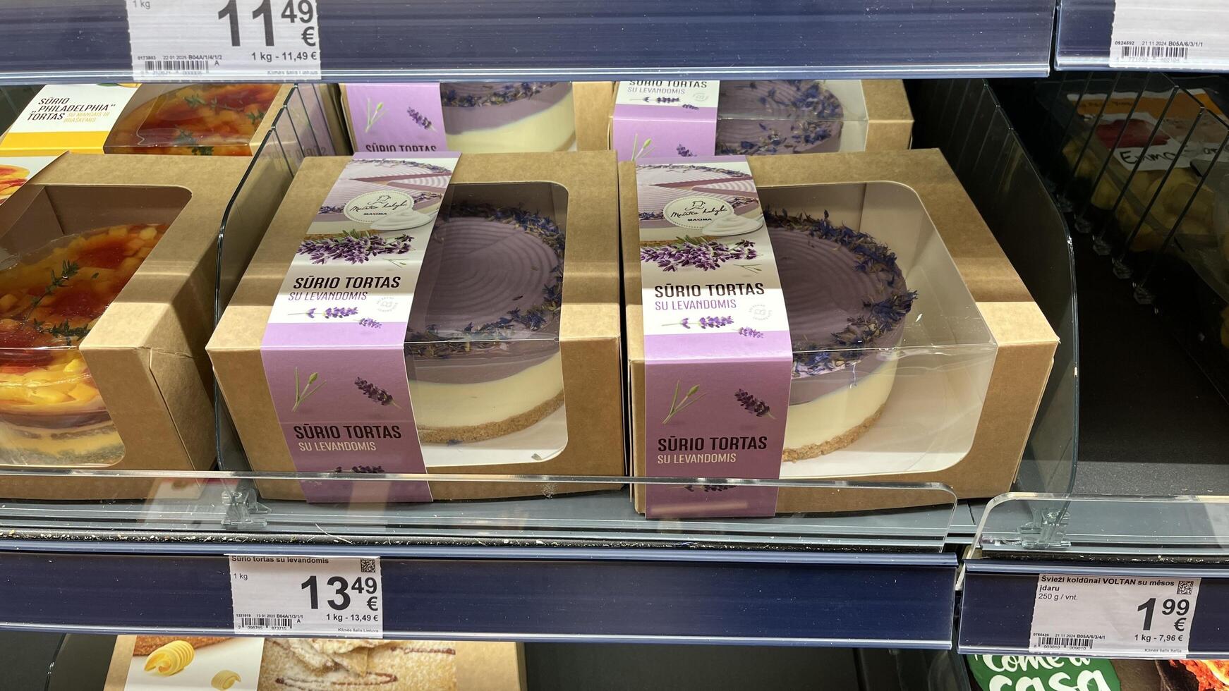 Kaunas, Lithuania. January 24, 2025. A well-stocked refrigerated display case showcases a variety of beautifully packaged cakes and desserts in various sizes and flavors in a grocery store setting. photo