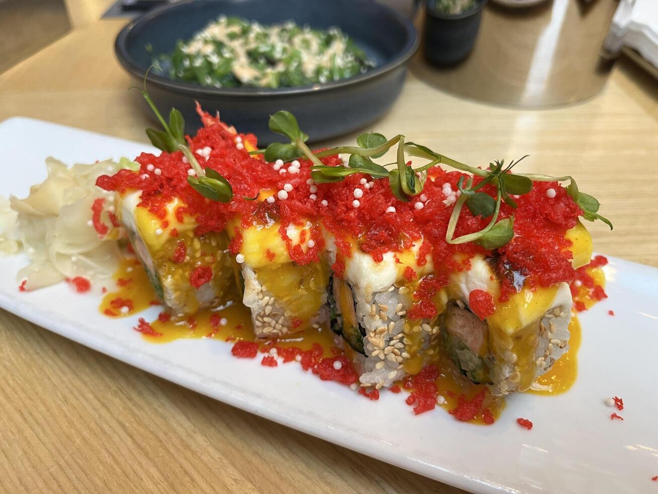 Delicious Red Dragon Sushi. Sushi with salmon, panko tiger prawns, cucumber, unagi sauce, mayonnaise, sesame seeds in Japanese restaurant photo