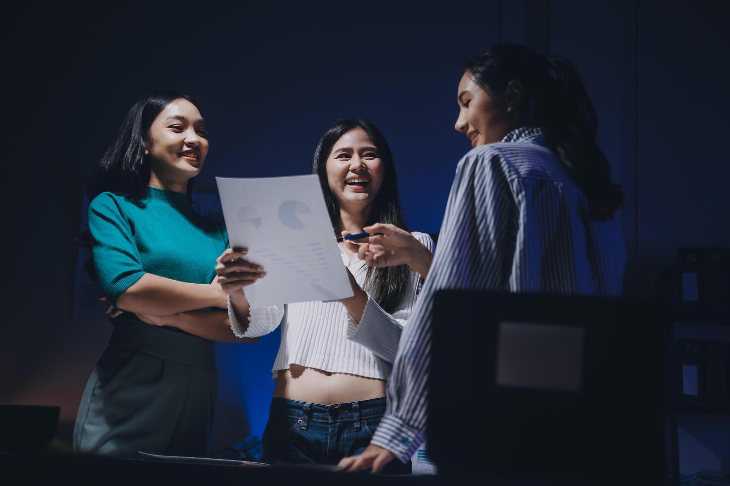 Three women standing in front of a computer screen photo