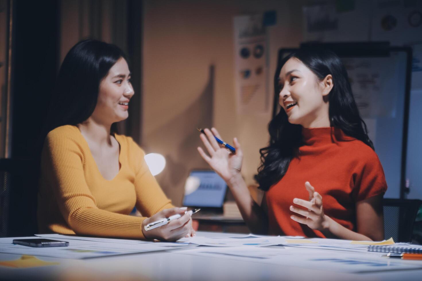 Two women talking at a table in an office photo