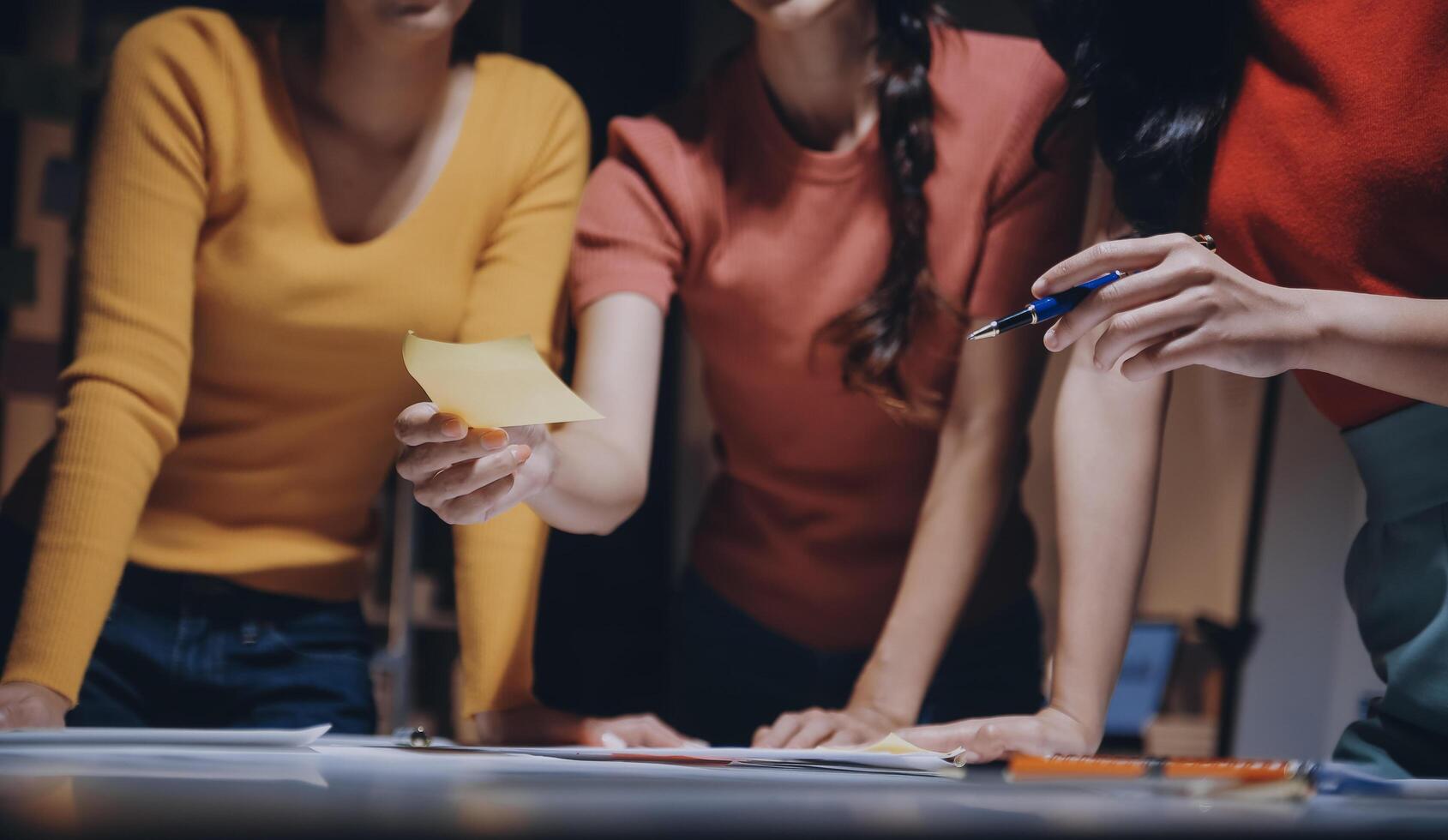 Three women are holding a piece of paper and a pen photo