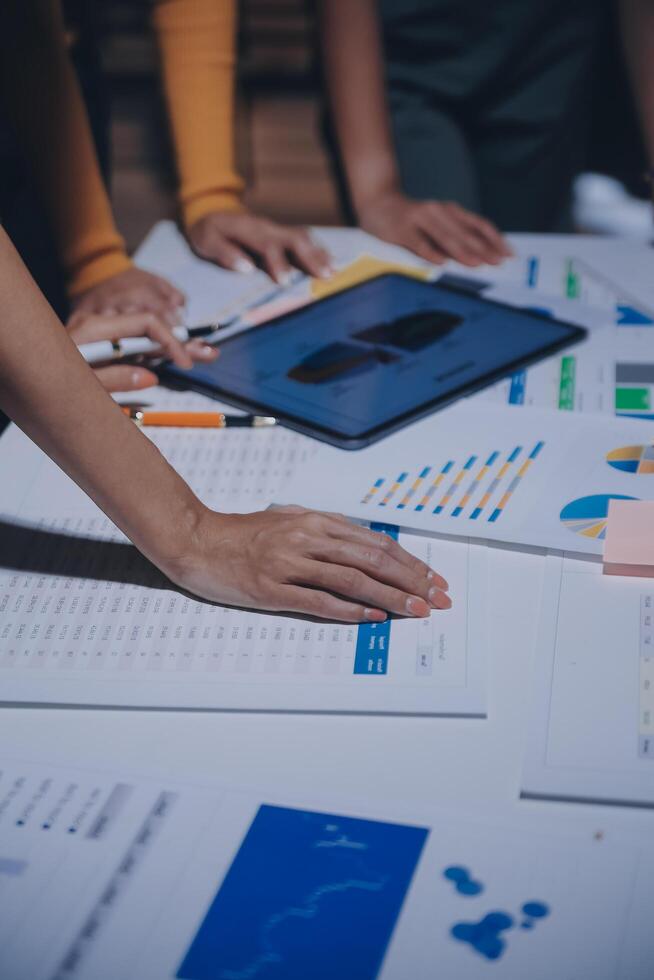 Business people working on a table with papers and graphs photo