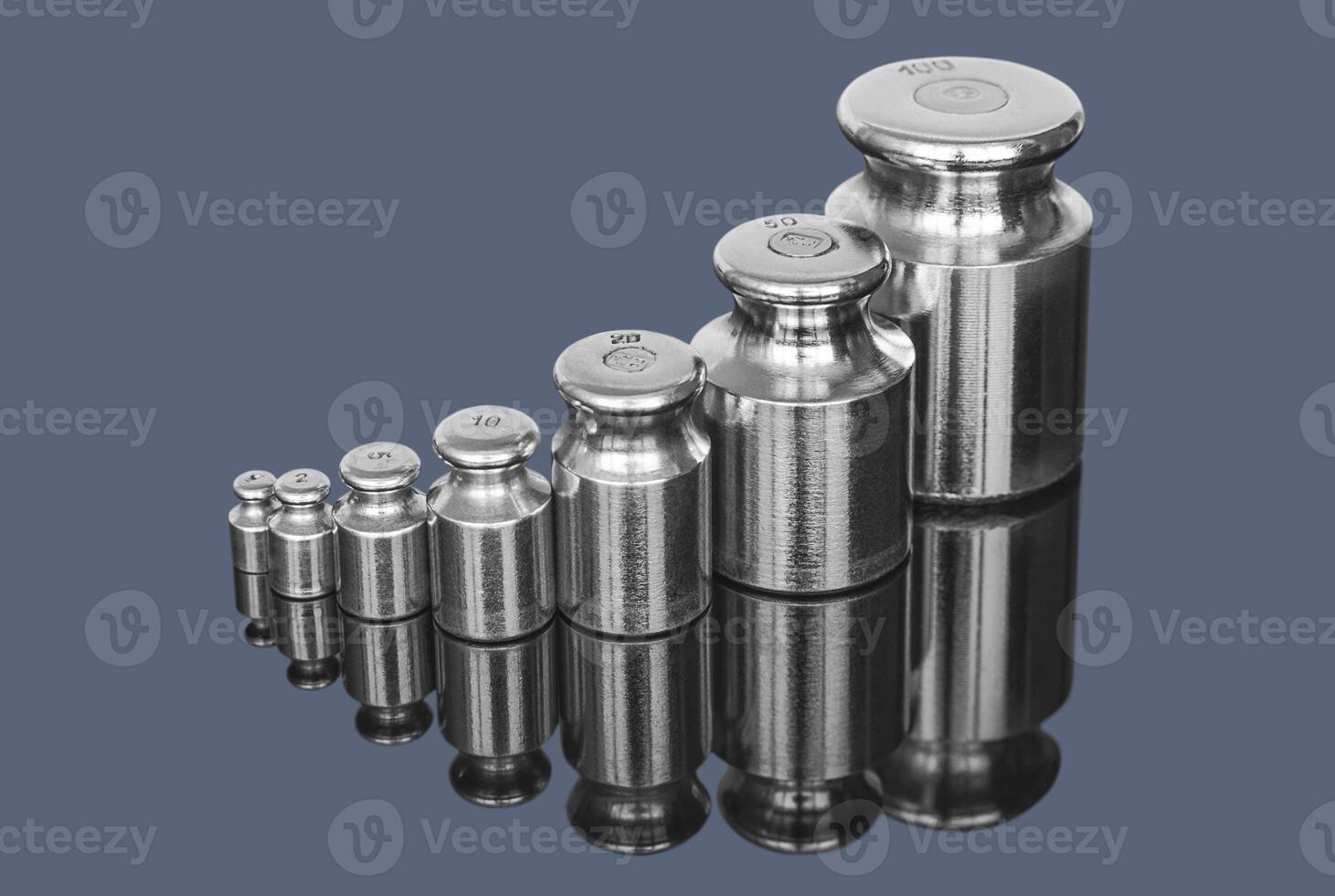 Set of metal weights for laboratory scales on dark background photo