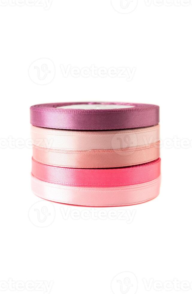 stack of satin ribbons in shades of pink against a white background photo