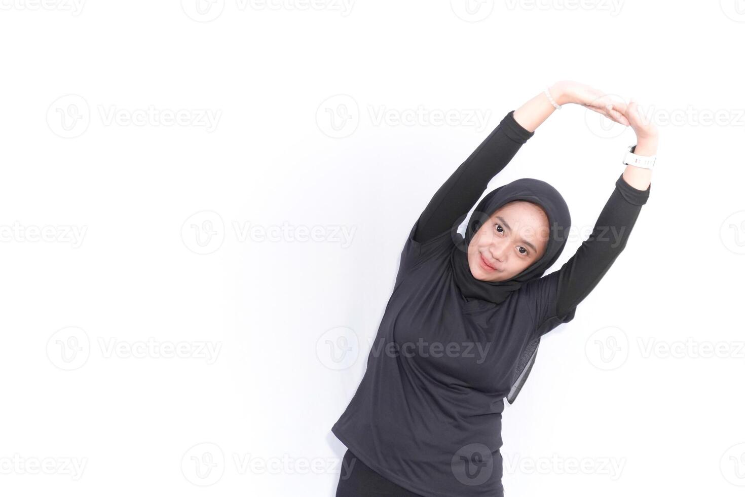 muslim woman in black outfit stretching her arms photo