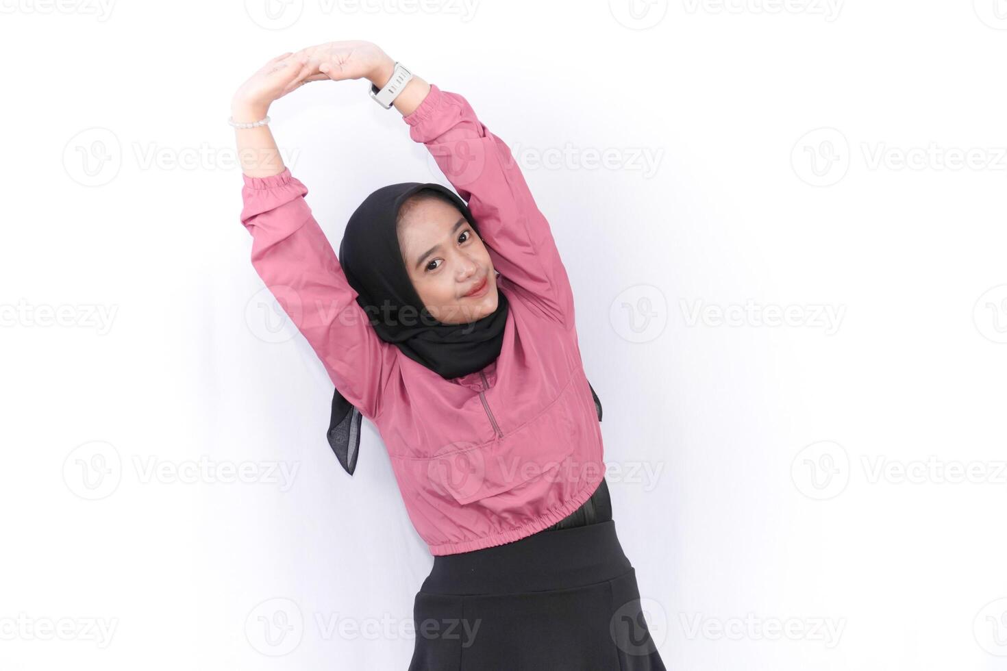 a woman in a pink shirt and skirt stretching photo
