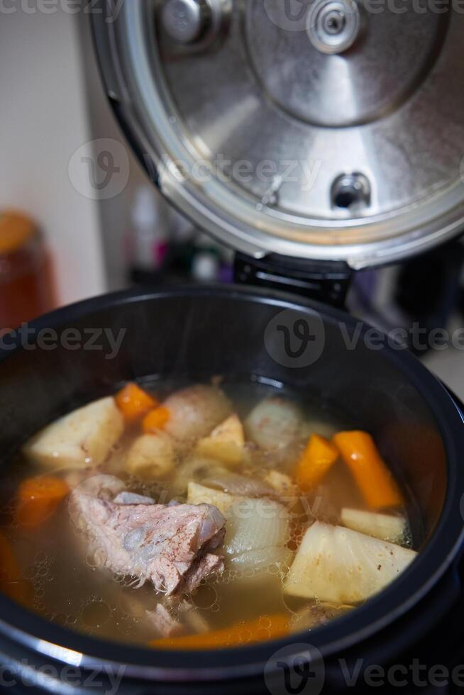 A pot of soup with carrots and potatoes photo