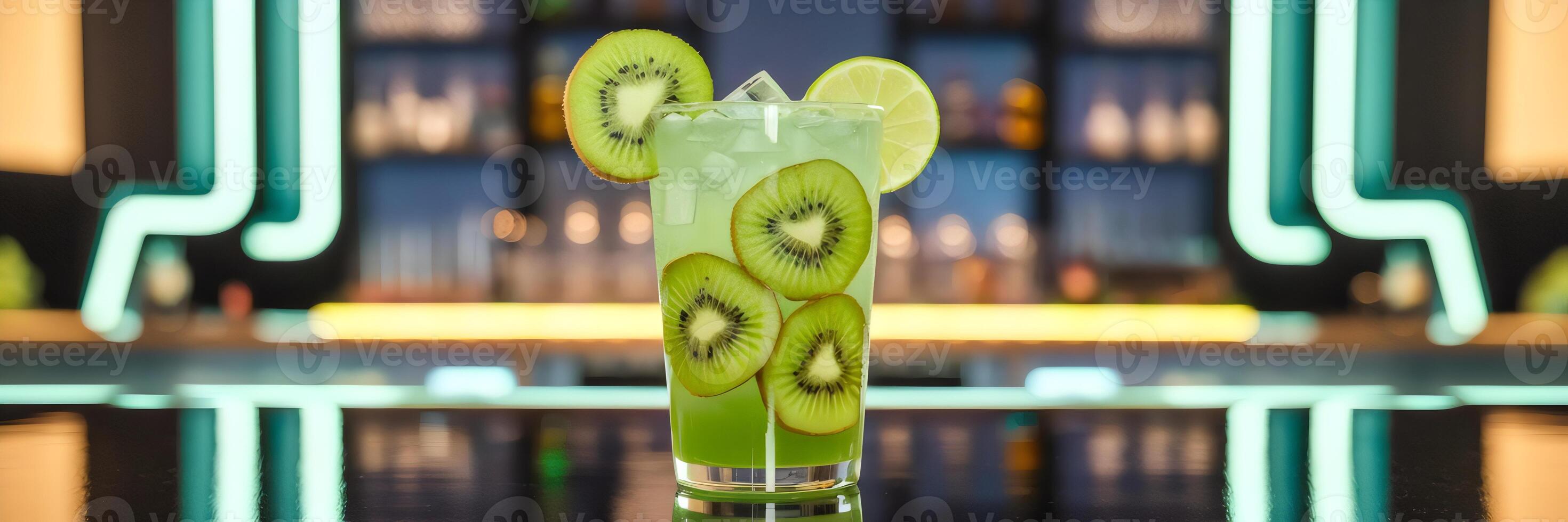 Tall glass of kiwi lime cooler with green liquid, kiwi slices, lime wedges, and neon bar background photo
