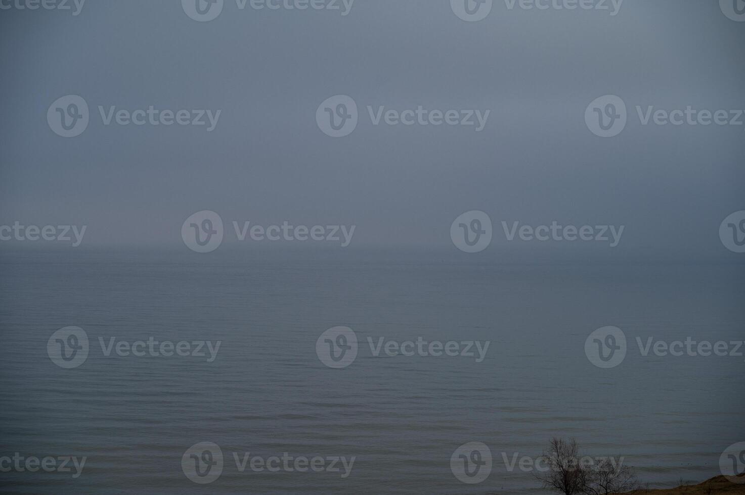 seascape with fog over the sea. sea horizon is visible, thick fog stands over the surface of the sea. land is not visible. photo