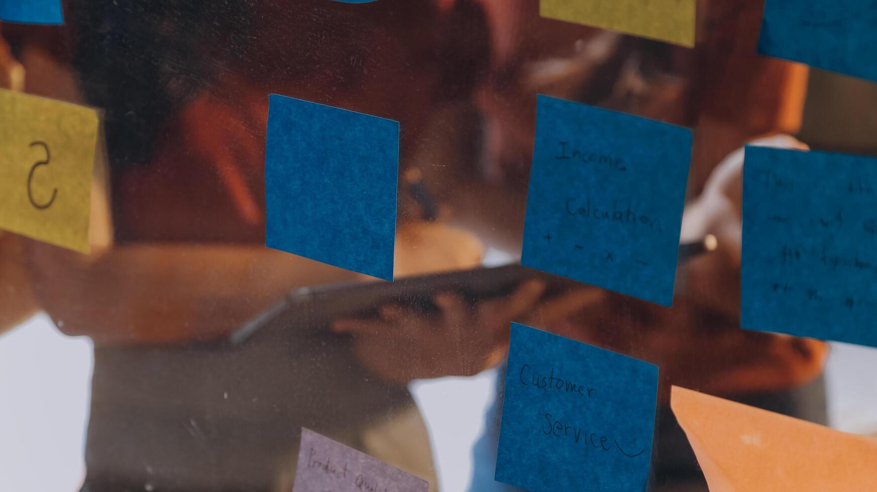 People looking at sticky notes on a glass wall photo