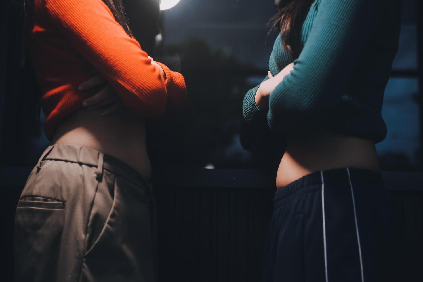 Two women standing next to each other in front of a window photo