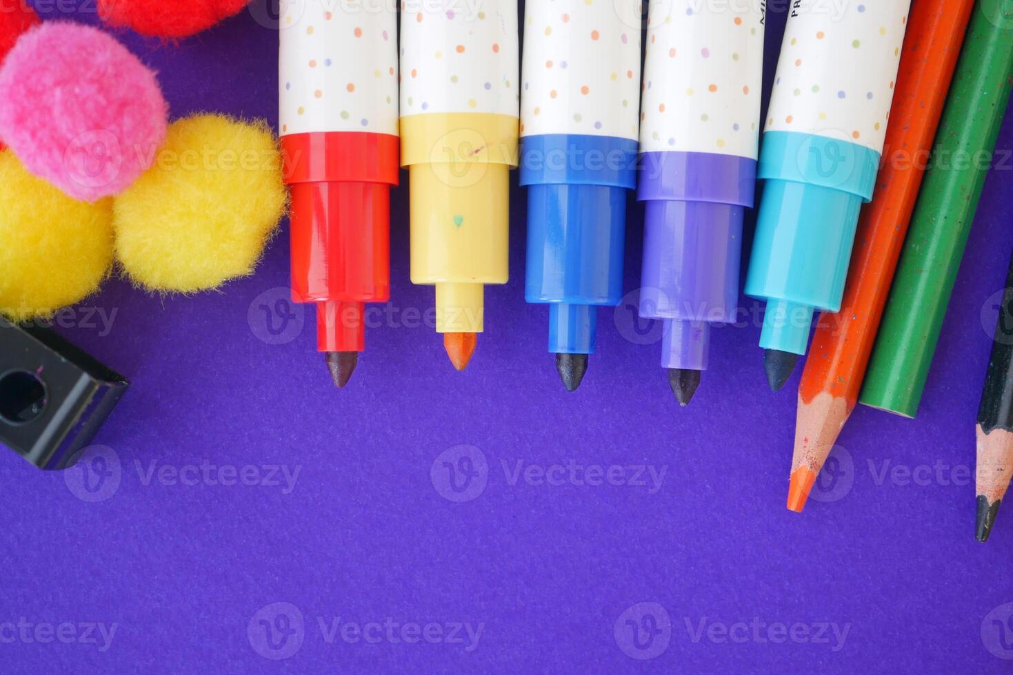 Colorful art supplies arranged on a purple surface photo