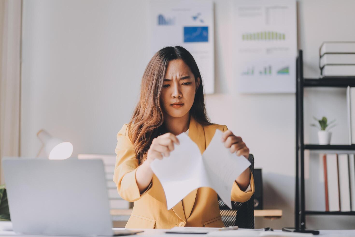A woman in a business suit is holding a piece of paper photo