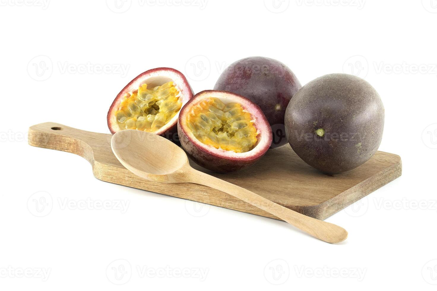 Fresh passion fruits and wooden spoon lying on cutting board photo