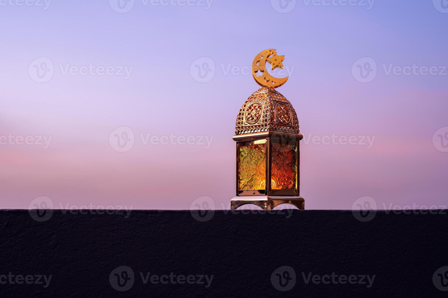 Golden lantern that have moon symbol on top with dusk sky background. photo