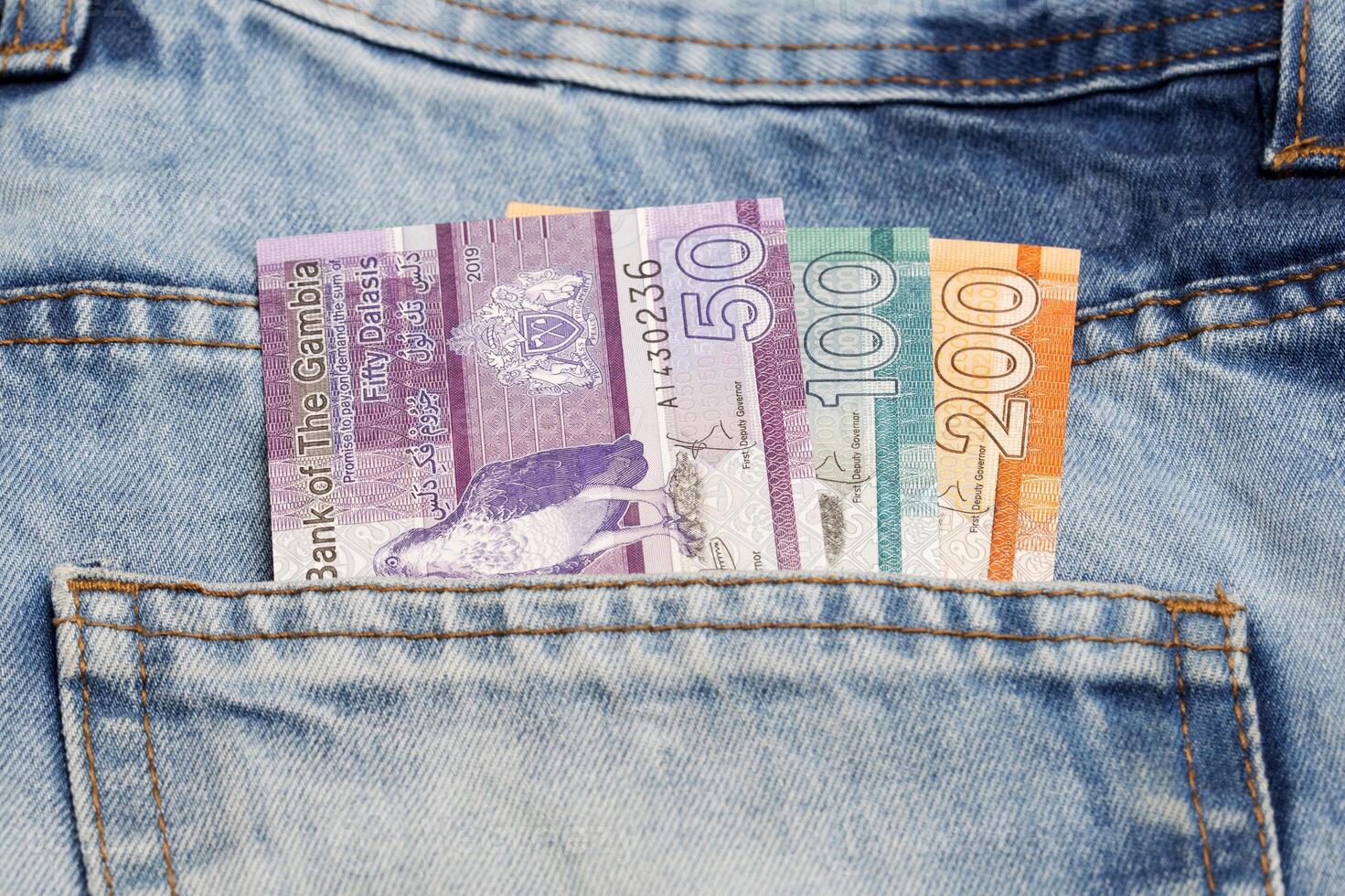 Gambian money - dalasi in the pocket of blue jeans photo