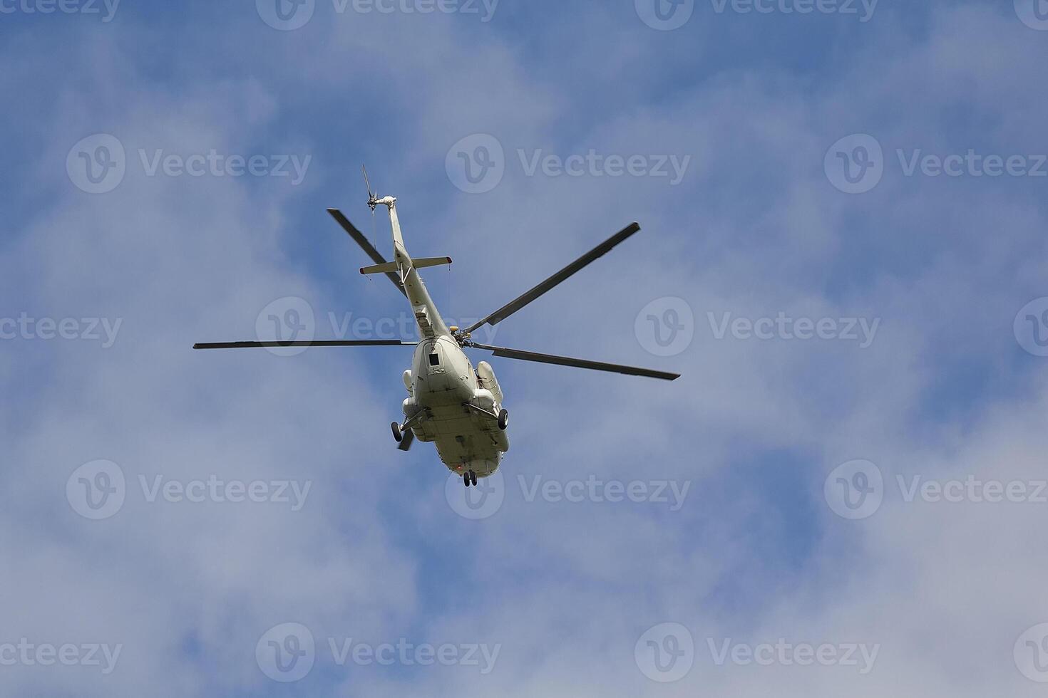 Helicopter flies against a blue sky background photo
