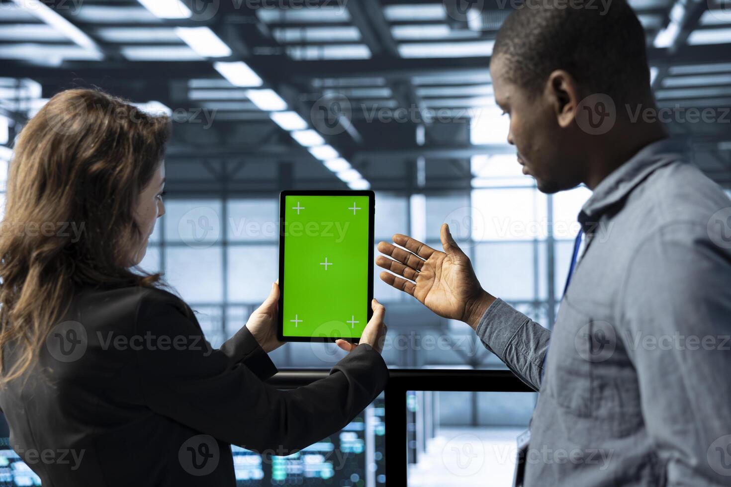 Team of engineers working in server farm, using chroma key tablet to analyze data. Employees working together in data center using isolated screen device, ensuring system integrity and security photo