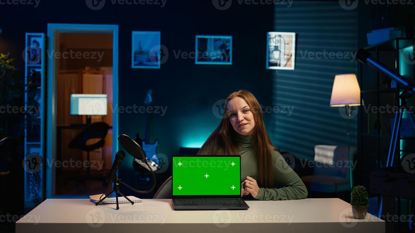 Young entertainer presenting green screen laptop from brand sponsoring , urging viewers to purchase it. Girl does influencer marketing by advertising mockup notebook to audience, camera B photo