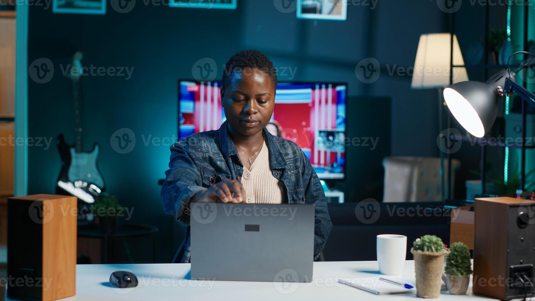 Woman arriving in apartment office, sitting down at desk, opening laptop to begin doing tasks. Teleworker starting job shift at home, preparing notebook device, logging in online, camera A photo