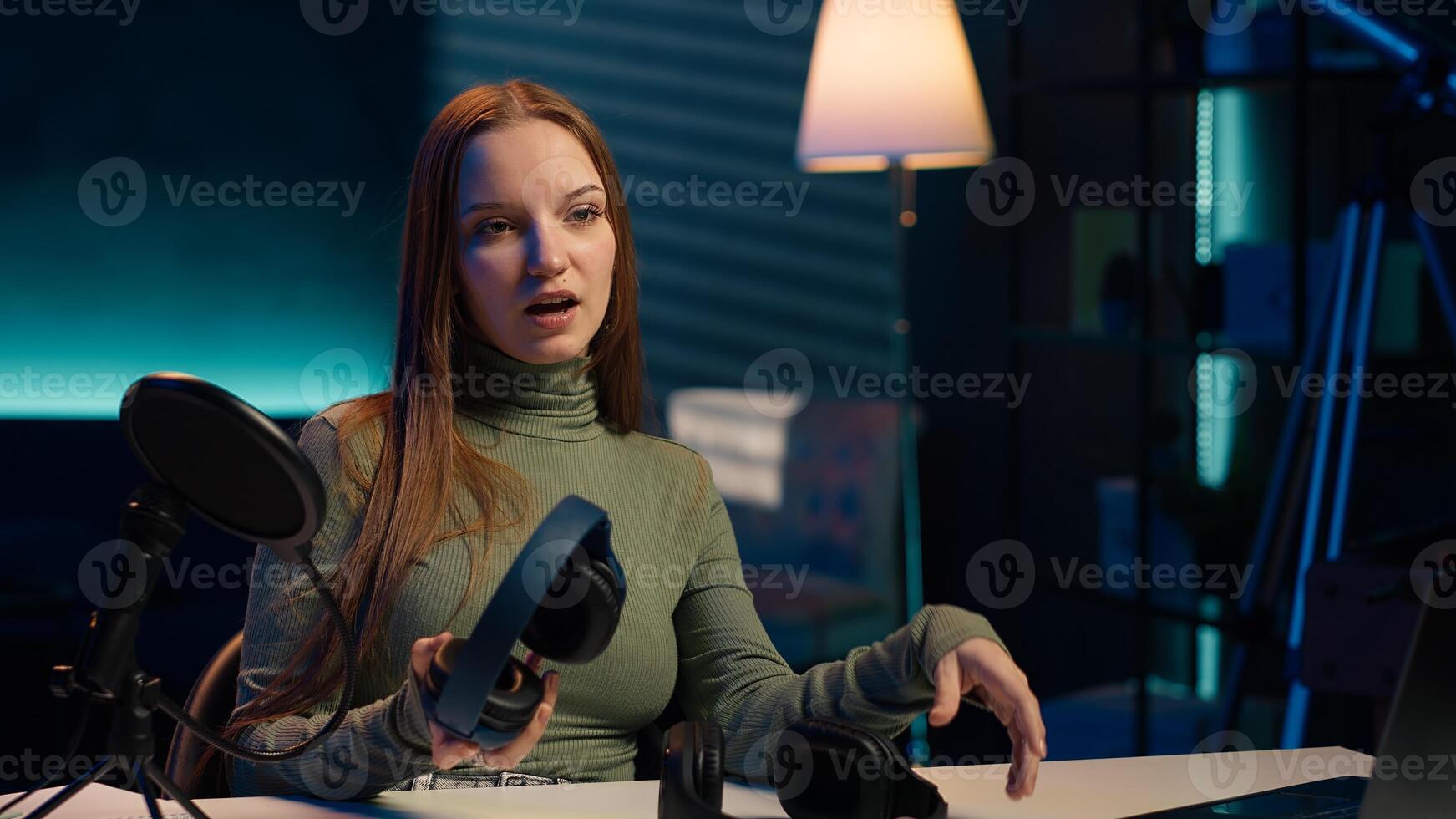 Gen Z influencer in home studio films headphones comparison for audience, recording with professional microphone to accurately capture sound, hosting technology internet show for fans, camera A photo