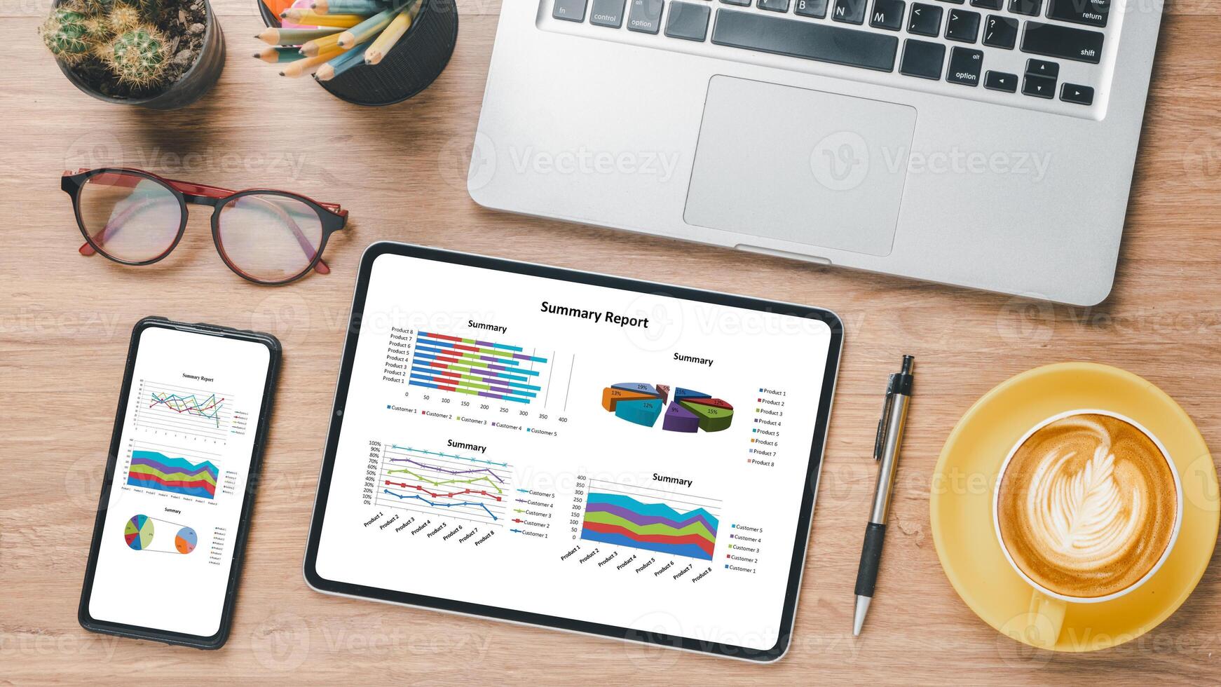 Tablet and smartphone with charts and reports on wooden desk workplace. Top view flat lay photo