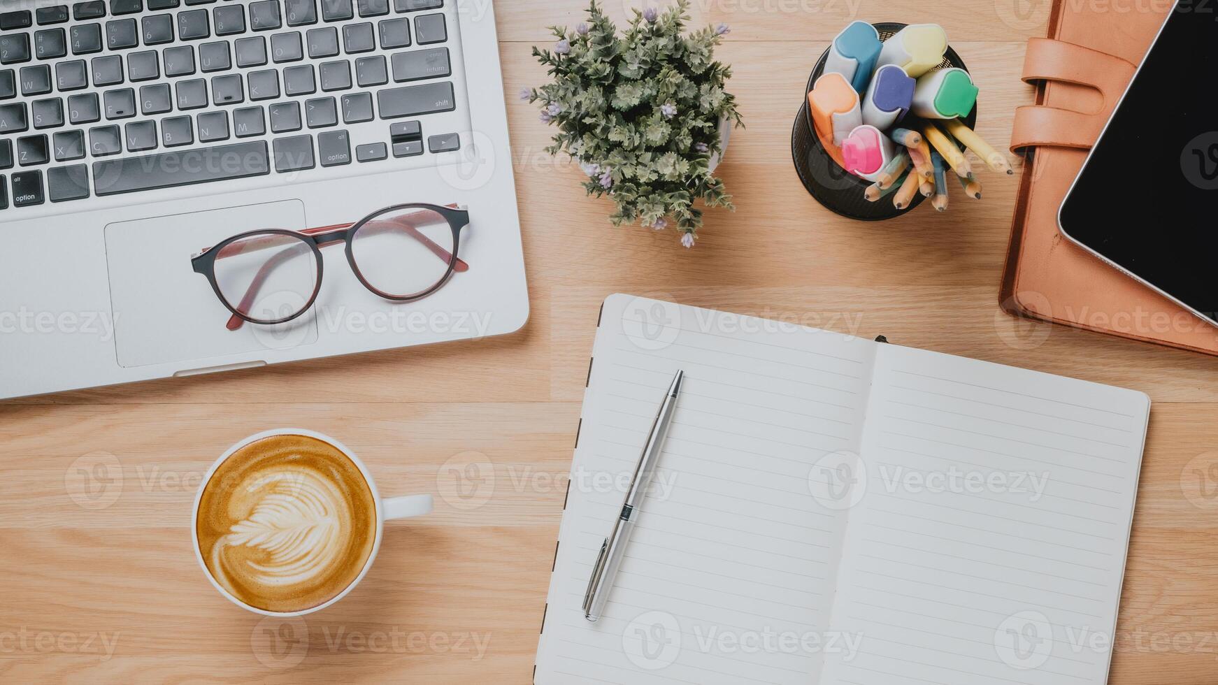 Office wooden desk workplace with laptop computer, tablet, notebook, pen and cup of coffee, Top view flat lay. photo