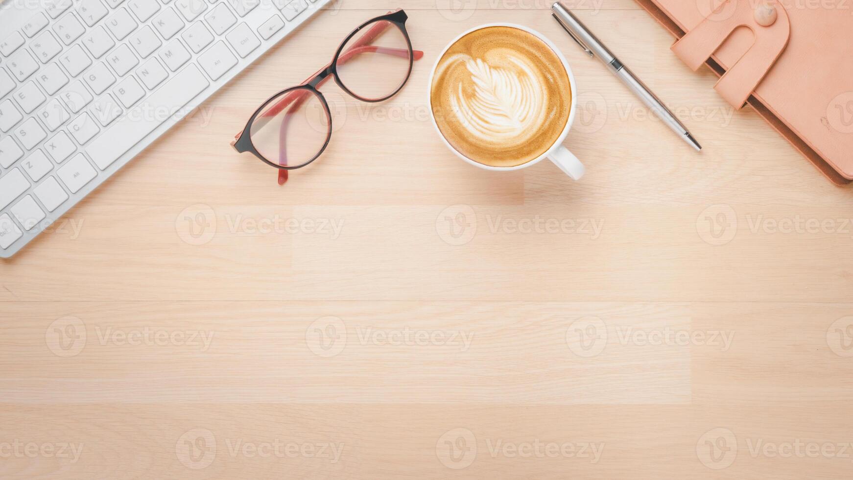 Office wooden desk workplace with keyboard computer, notebook, pen, eyeglass and cup of coffee, Top view flat lay with copy space. photo
