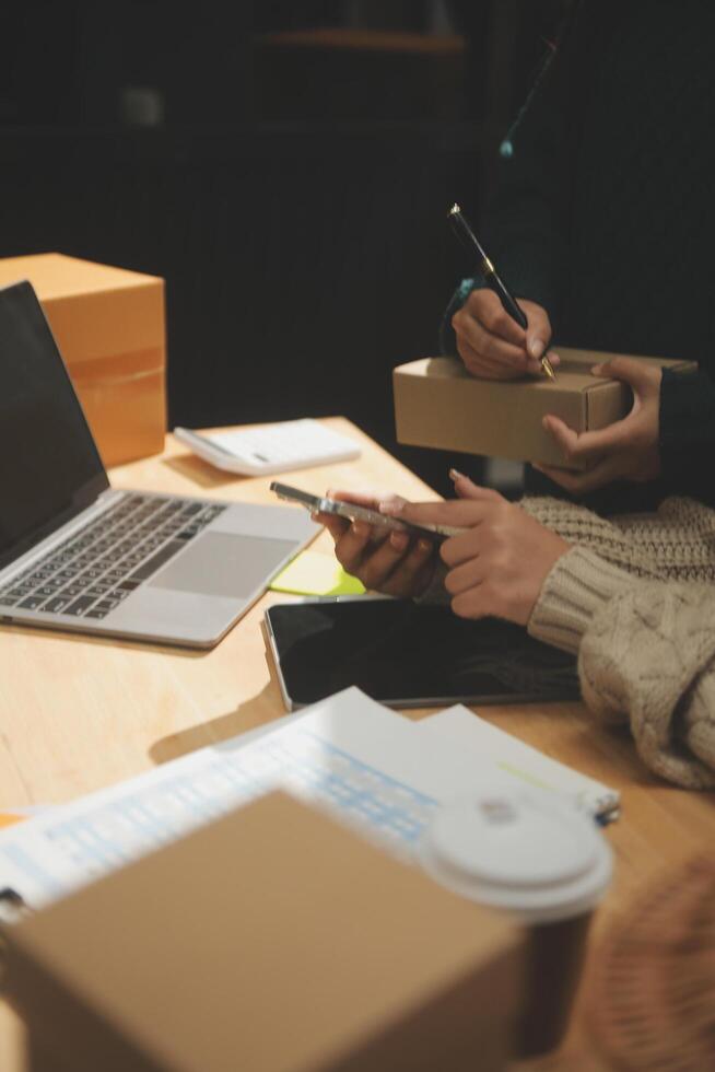 Two people working on a laptop at a desk photo