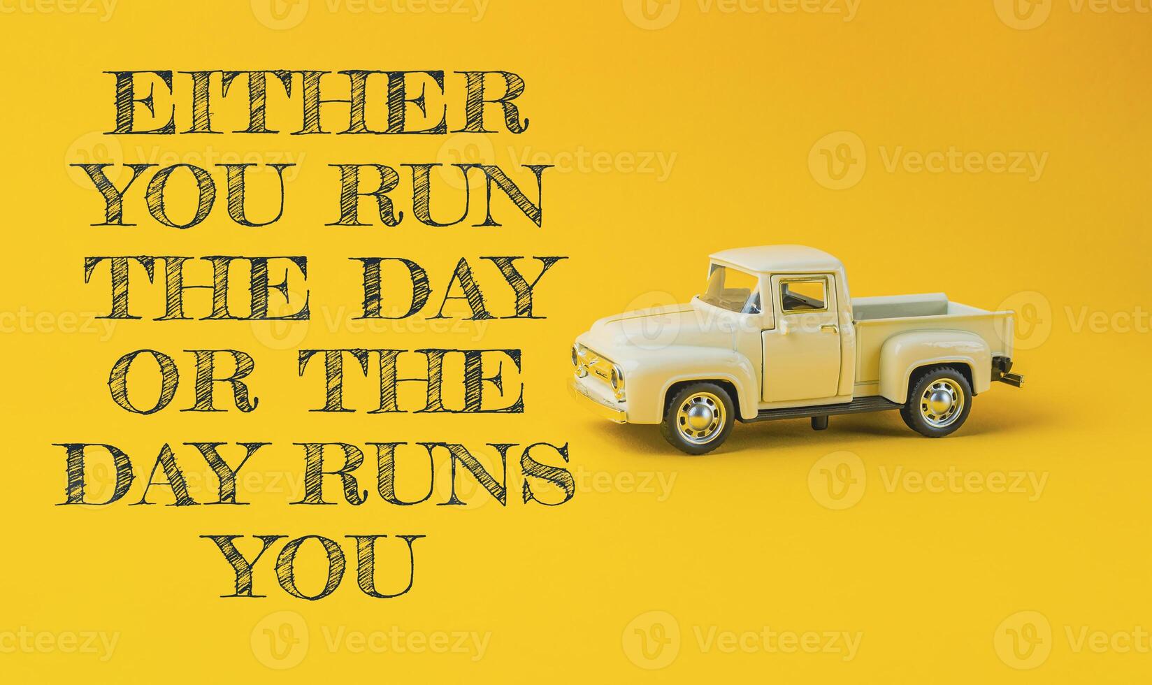 Yellow truck with the words either you run the day or the day runs you photo