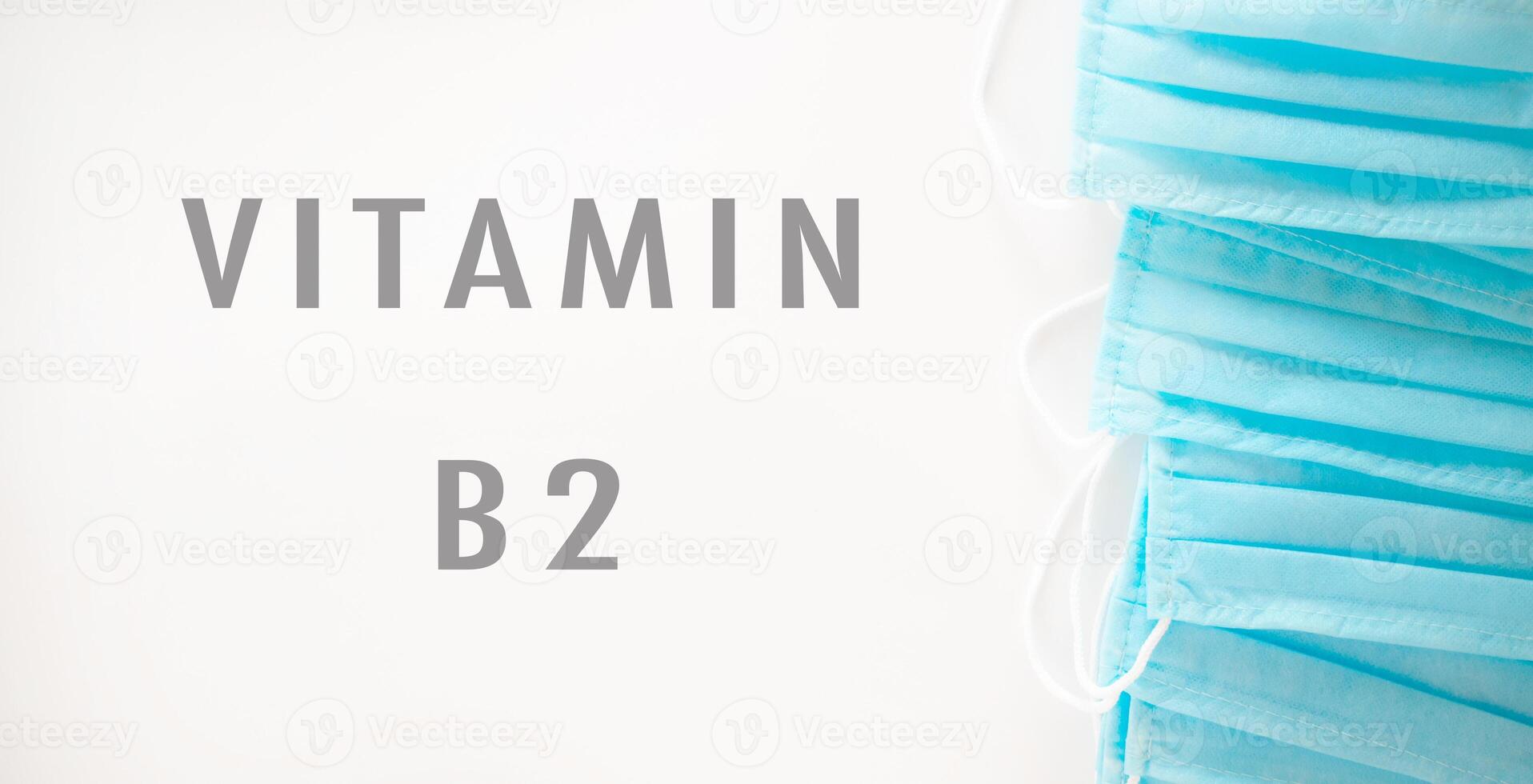 A blue stack of surgical masks with the word vitamin B2 written underneath photo