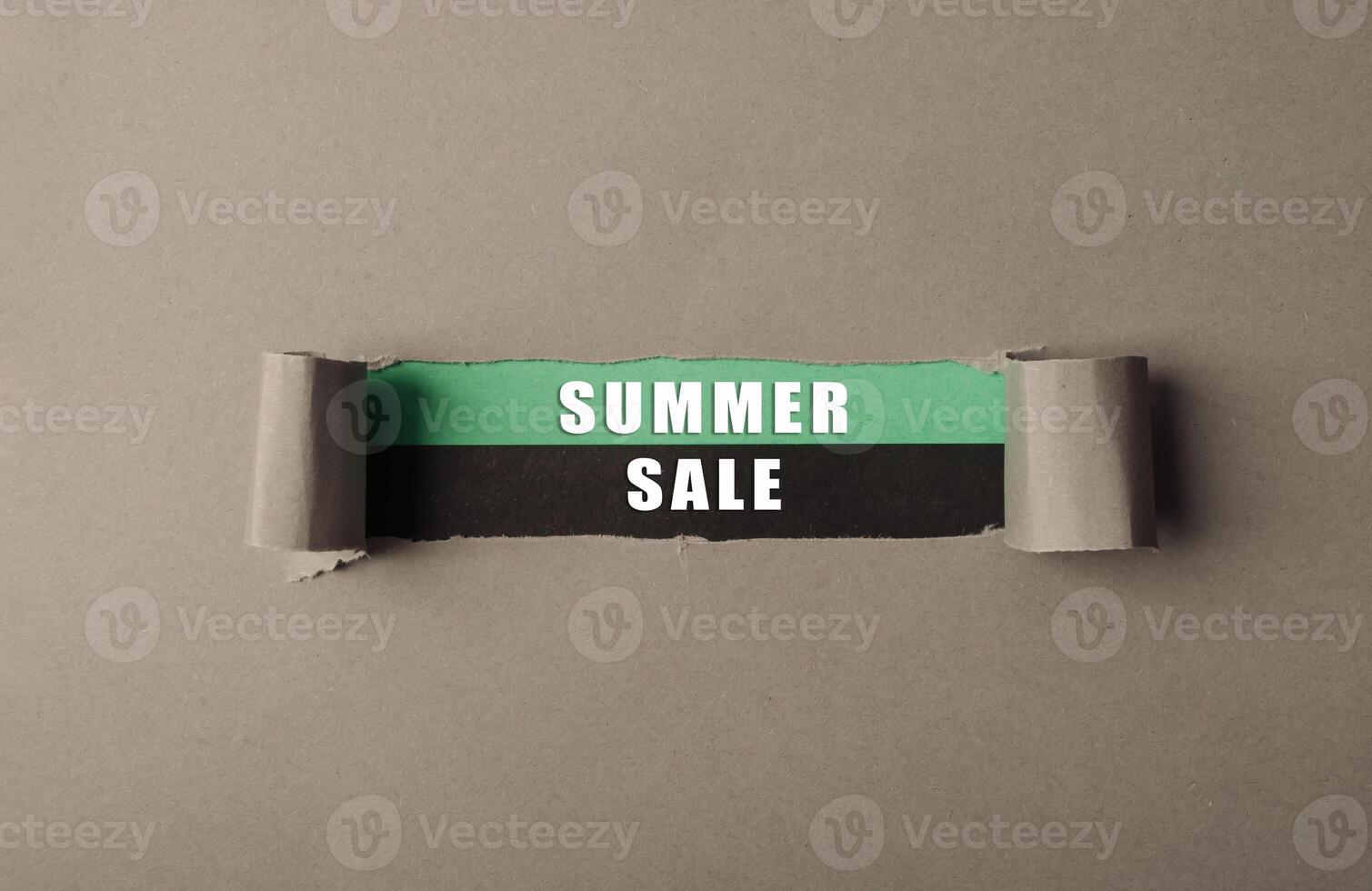 A torn piece of paper with the words Summer Sale written on it photo
