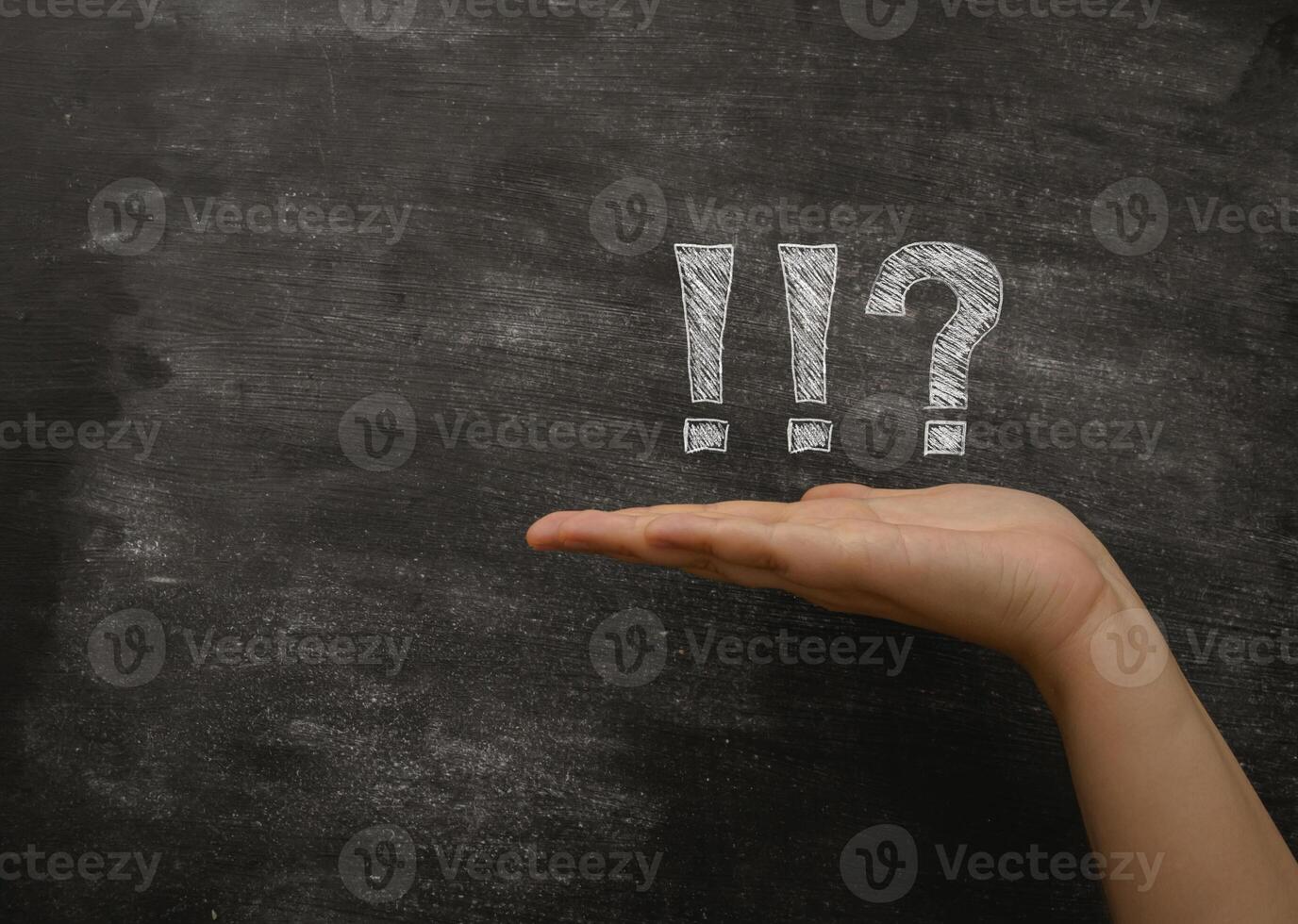 Hand is holding a chalkboard with a question mark and an exclamation point photo