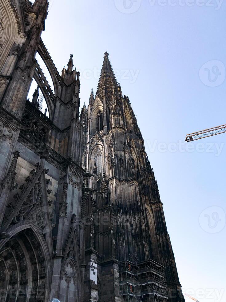 Cathedral in Cologne, Tall building with a pointed roof and a blue sky in the background photo