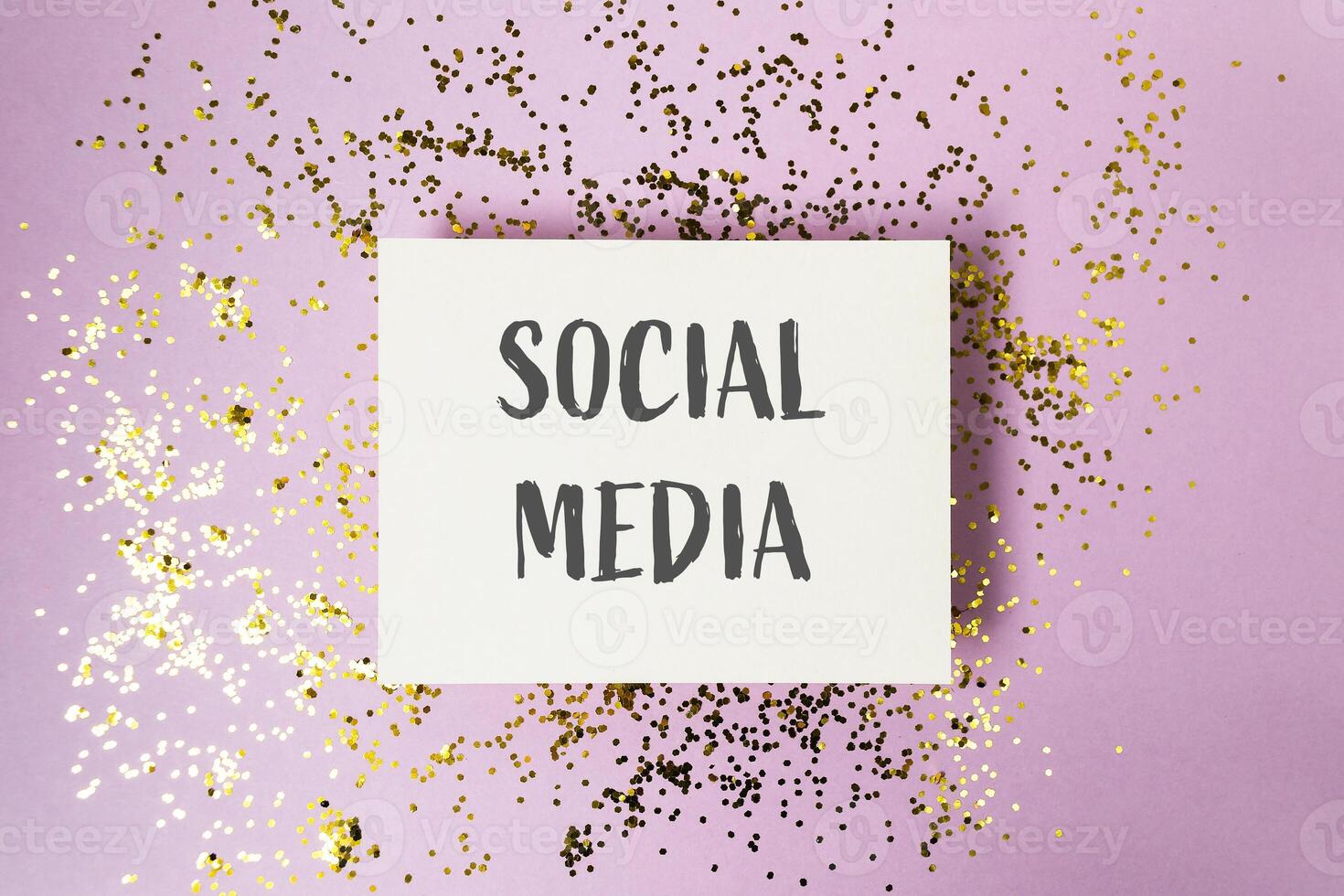 White card with gold glitter and the word social media written on it photo
