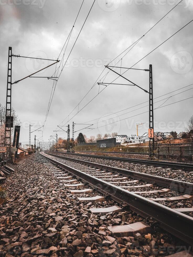 A train track with a cloudy sky in the background photo