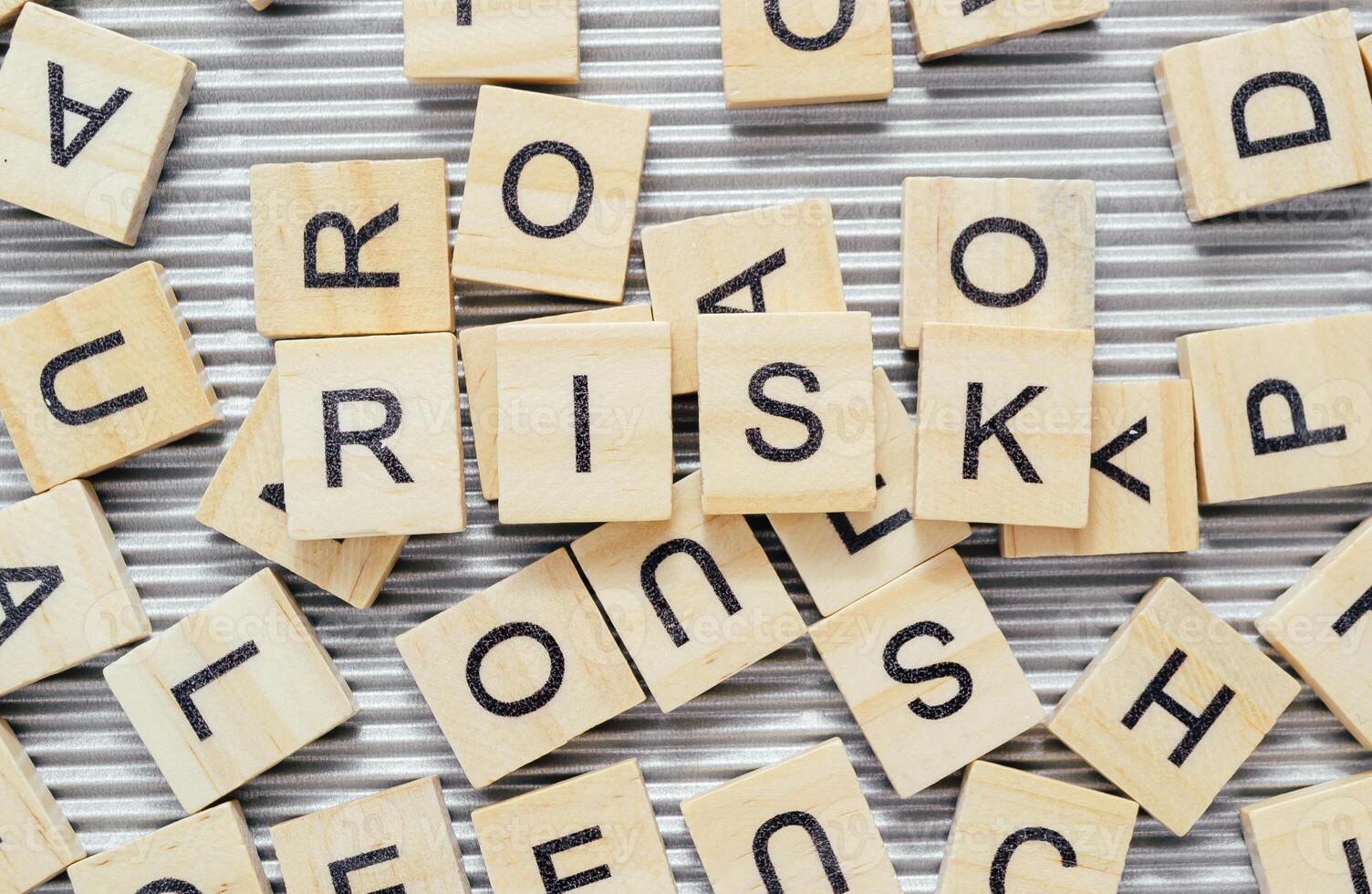 Word Risk surrounded by scattered wooden blocks with letters photo