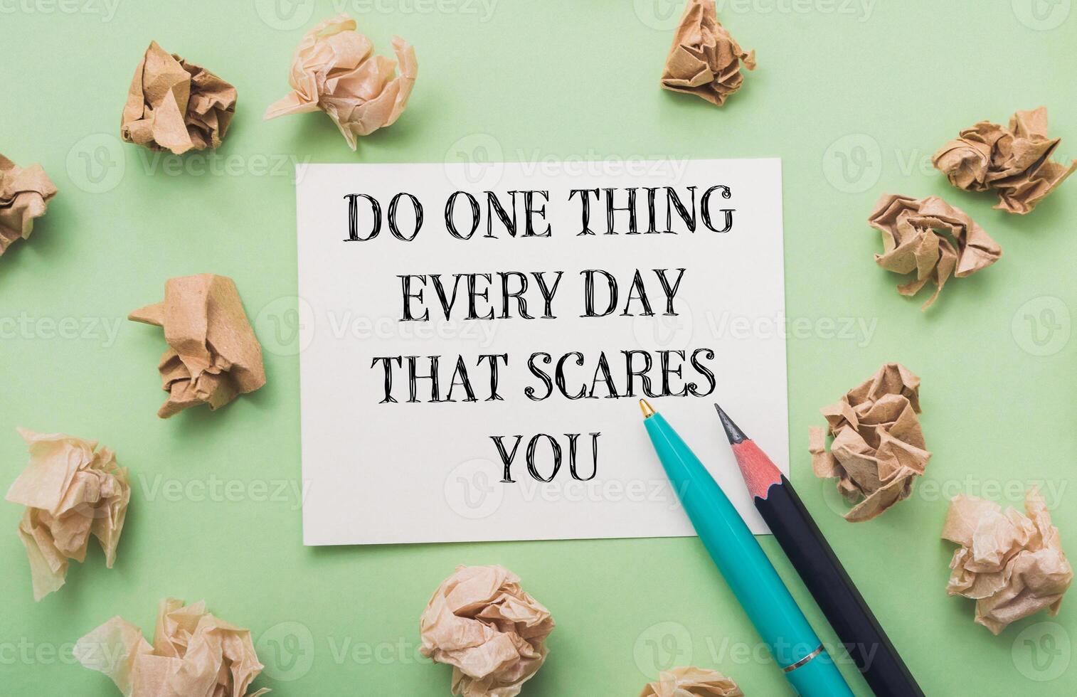 Piece of paper with the words Do one thing every day that scares you photo