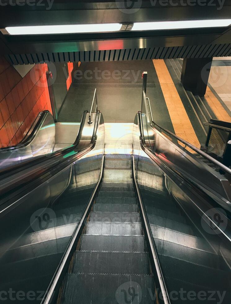 Long silver escalator with a red stripe down the middle photo