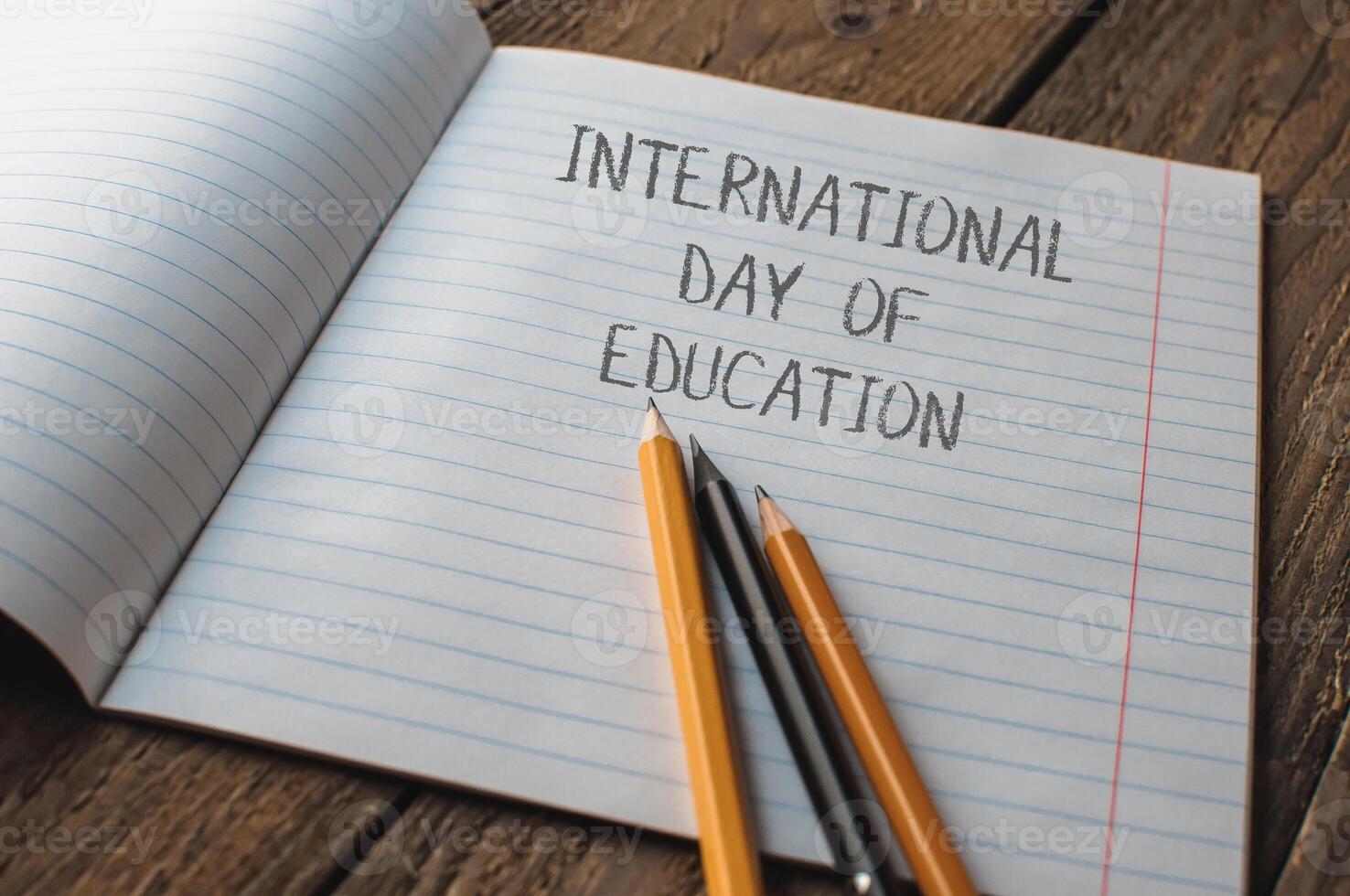 A notebook with pencils on it and the words International Day of Education photo