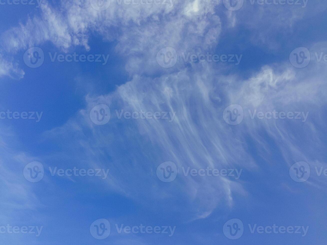 The sky is blue and clear with a few clouds scattered throughout photo