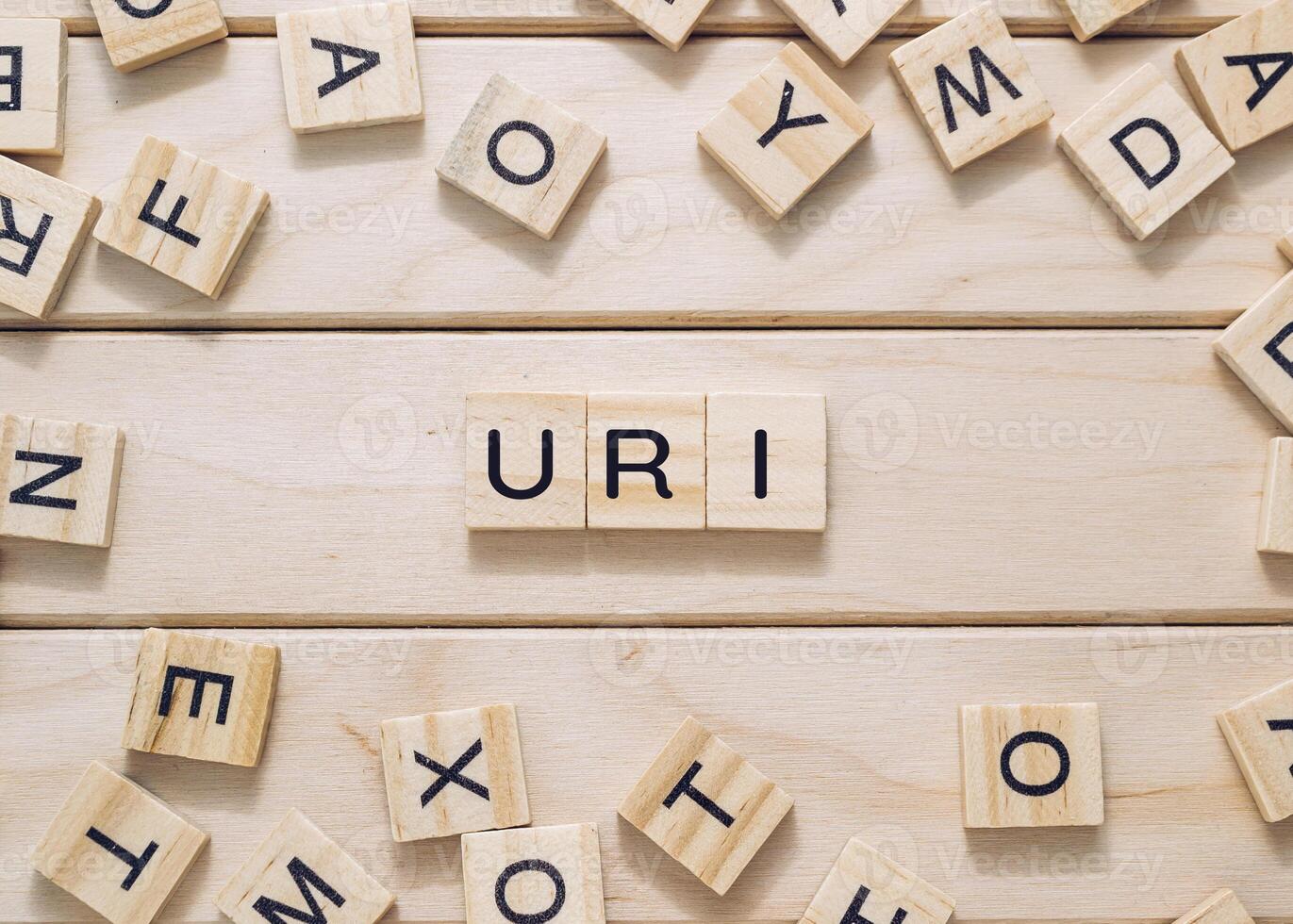 A jumble of wooden letters spell out the word uri photo