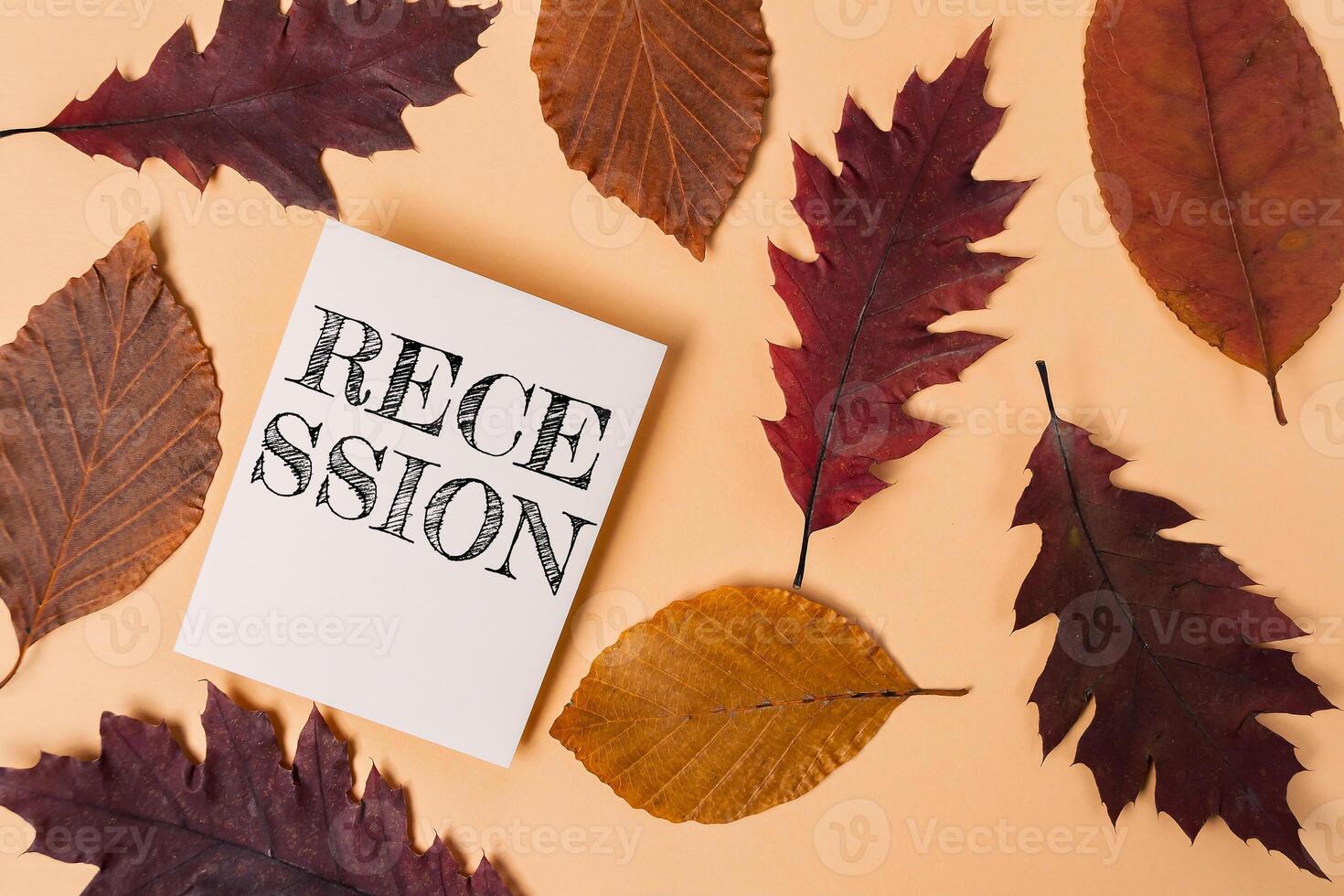 White piece of paper with the word recession written on it is placed on top of photo